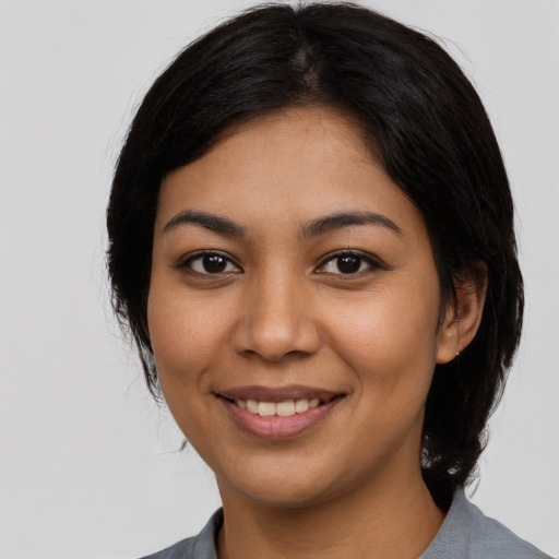 Joyful latino young-adult female with medium  black hair and brown eyes