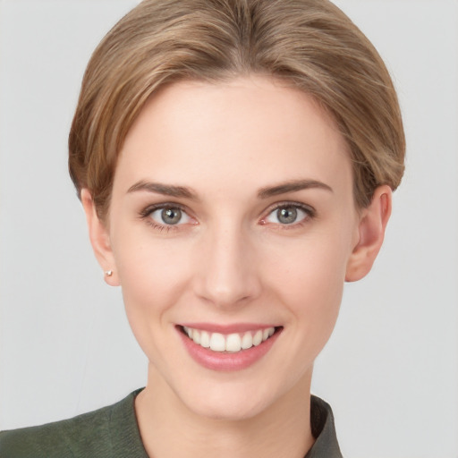 Joyful white young-adult female with short  brown hair and grey eyes