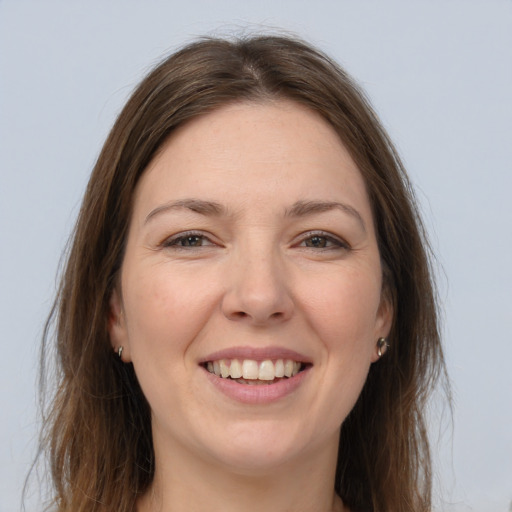 Joyful white young-adult female with long  brown hair and brown eyes