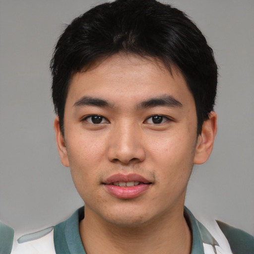 Joyful asian young-adult male with short  black hair and brown eyes