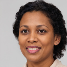 Joyful black adult female with long  brown hair and brown eyes