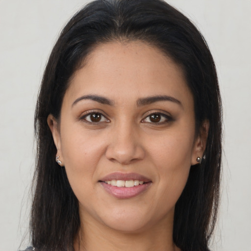 Joyful latino young-adult female with long  brown hair and brown eyes