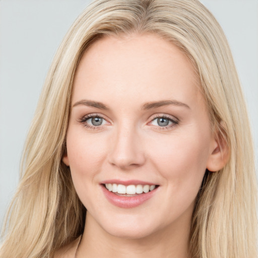 Joyful white young-adult female with long  brown hair and blue eyes