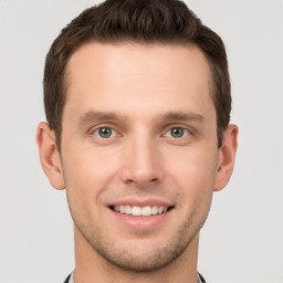 Joyful white young-adult male with short  brown hair and grey eyes