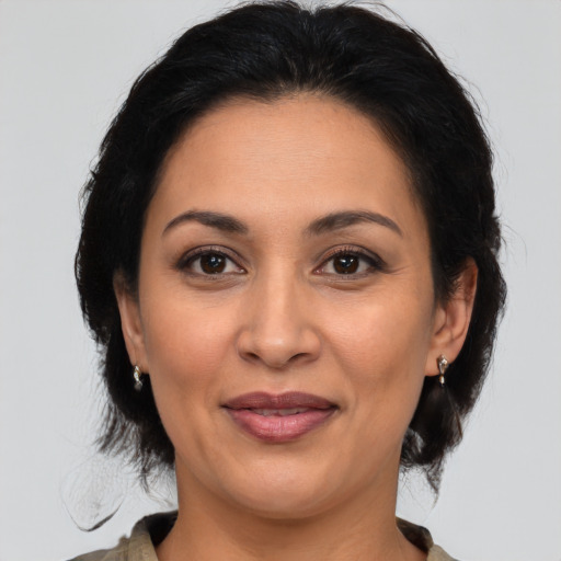 Joyful latino adult female with medium  brown hair and brown eyes