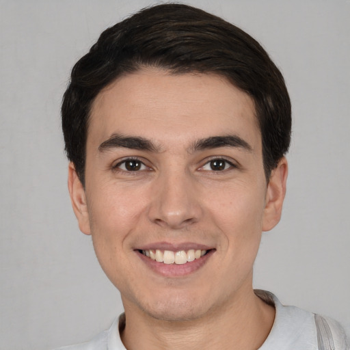 Joyful white young-adult male with short  black hair and brown eyes