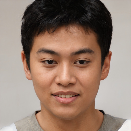 Joyful asian young-adult male with short  brown hair and brown eyes