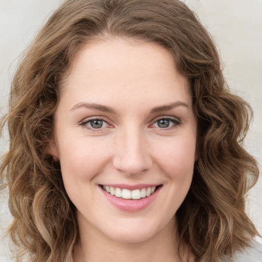 Joyful white young-adult female with medium  brown hair and green eyes