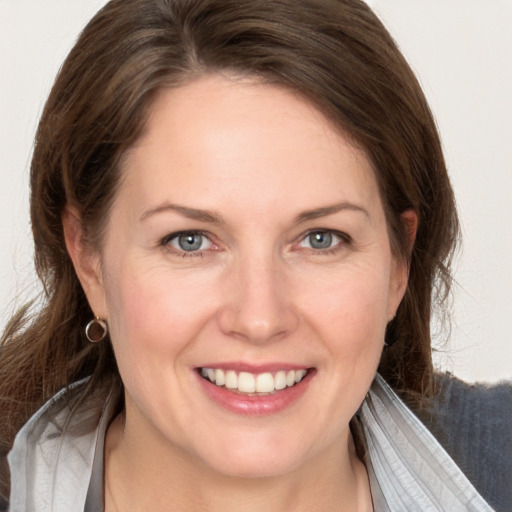 Joyful white adult female with medium  brown hair and grey eyes