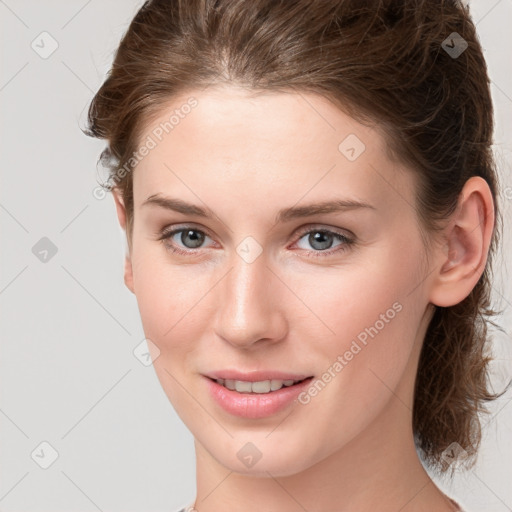 Joyful white young-adult female with medium  brown hair and grey eyes