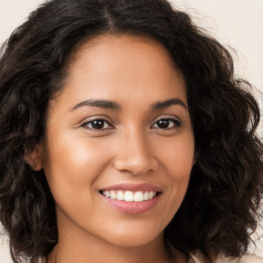 Joyful latino young-adult female with long  brown hair and brown eyes