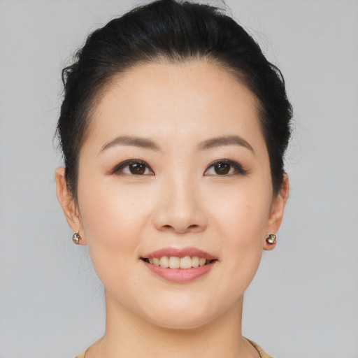 Joyful asian young-adult female with short  brown hair and brown eyes