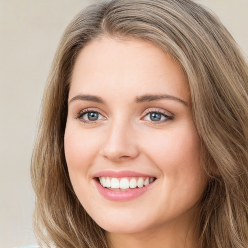 Joyful white young-adult female with long  brown hair and green eyes