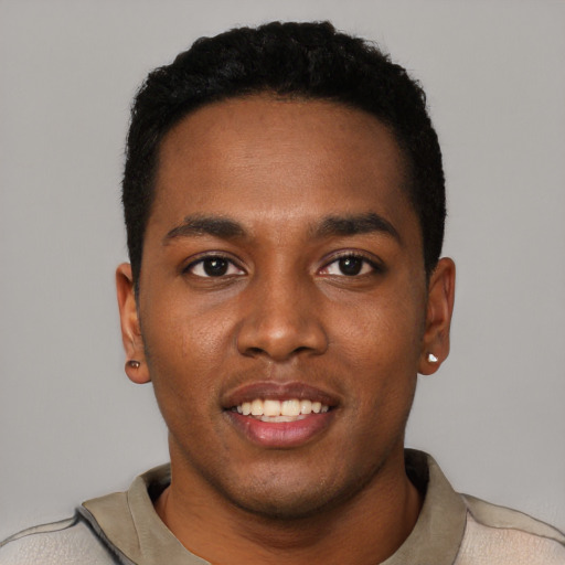 Joyful black young-adult male with short  black hair and brown eyes