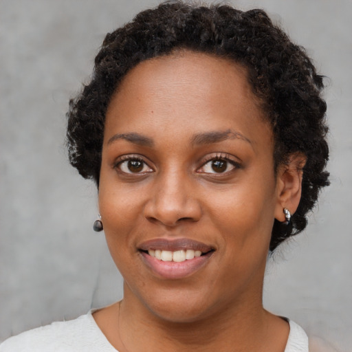 Joyful black young-adult female with short  brown hair and brown eyes