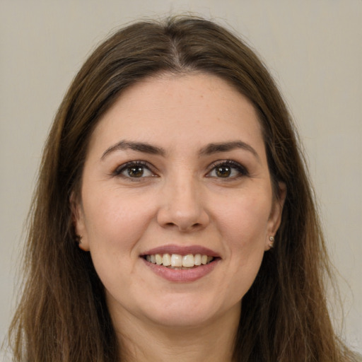 Joyful white young-adult female with long  brown hair and brown eyes