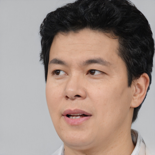 Joyful asian adult male with short  black hair and brown eyes