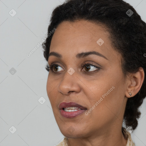 Joyful black young-adult female with short  black hair and brown eyes