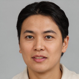 Joyful asian young-adult male with short  brown hair and brown eyes