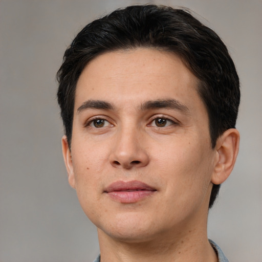 Joyful white young-adult male with short  black hair and brown eyes