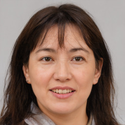 Joyful white adult female with long  brown hair and brown eyes