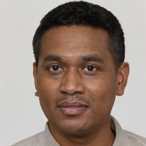 Joyful black adult male with short  black hair and brown eyes