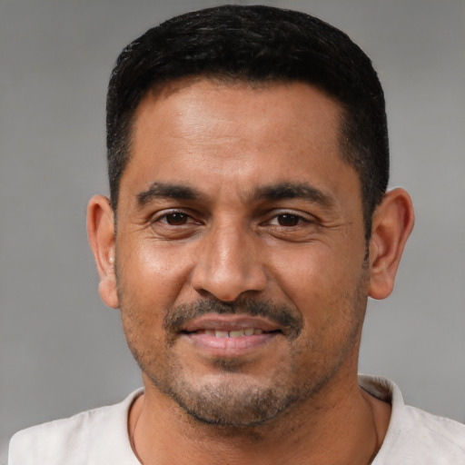 Joyful latino adult male with short  black hair and brown eyes