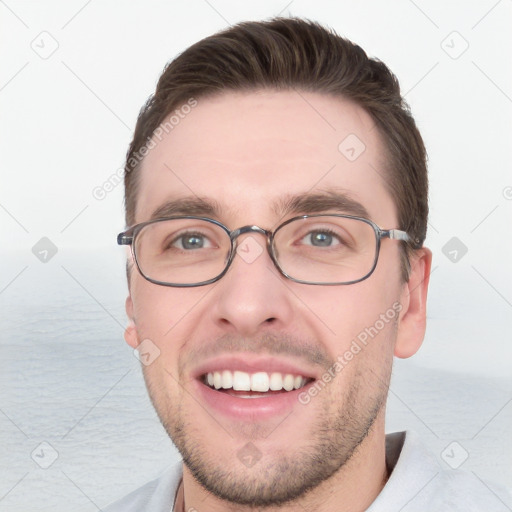 Joyful white young-adult male with short  brown hair and grey eyes