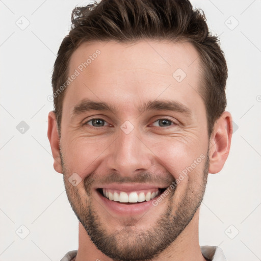 Joyful white young-adult male with short  brown hair and grey eyes