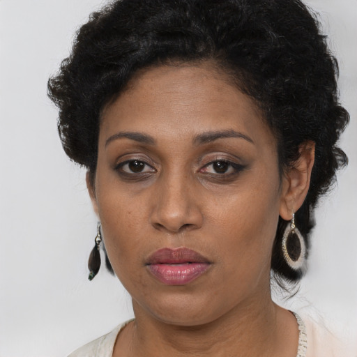 Joyful black adult female with medium  brown hair and brown eyes
