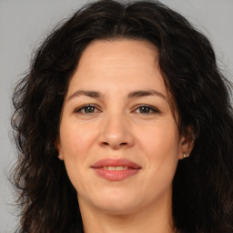 Joyful white adult female with long  brown hair and brown eyes