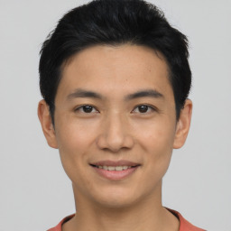 Joyful asian young-adult male with short  black hair and brown eyes