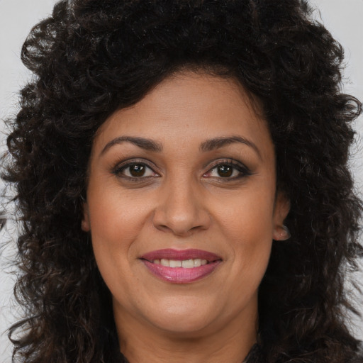 Joyful latino adult female with long  brown hair and brown eyes