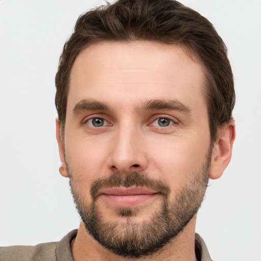 Joyful white young-adult male with short  brown hair and grey eyes