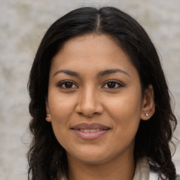 Joyful latino young-adult female with long  brown hair and brown eyes