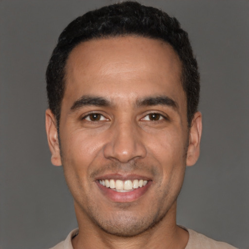 Joyful white young-adult male with short  black hair and brown eyes