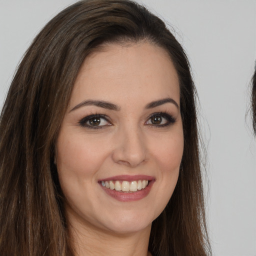 Joyful white young-adult female with long  brown hair and brown eyes