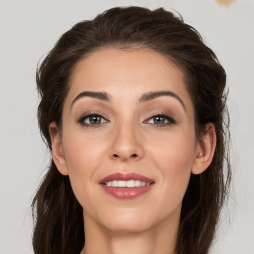 Joyful white young-adult female with long  brown hair and brown eyes