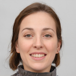 Joyful white young-adult female with medium  brown hair and grey eyes