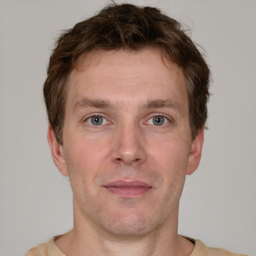 Joyful white adult male with short  brown hair and grey eyes