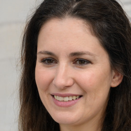 Joyful white adult female with long  brown hair and brown eyes