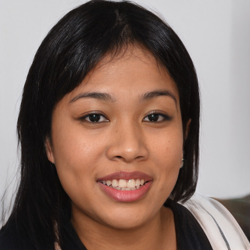 Joyful latino young-adult female with long  brown hair and brown eyes