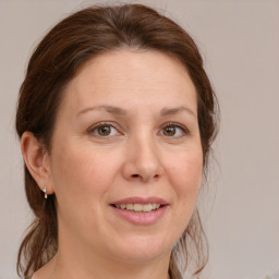 Joyful white adult female with medium  brown hair and blue eyes