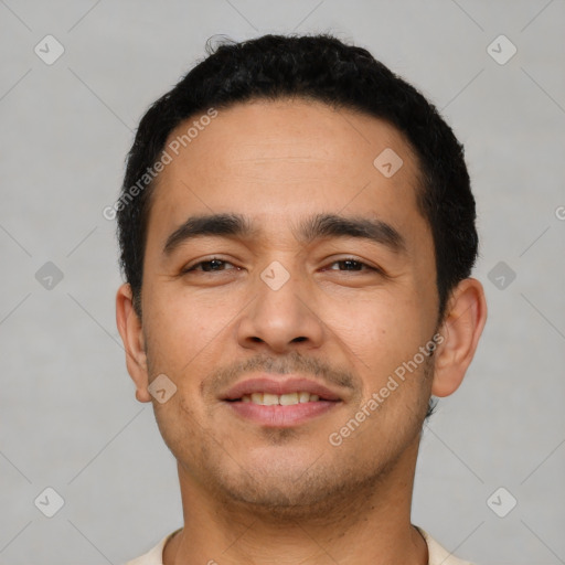 Joyful latino young-adult male with short  black hair and brown eyes