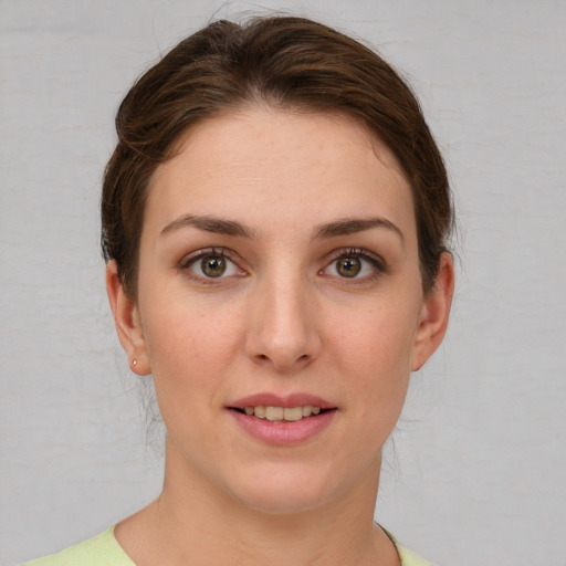 Joyful white young-adult female with short  brown hair and green eyes