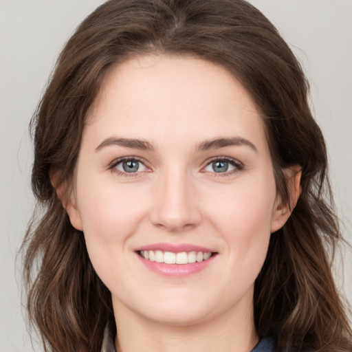 Joyful white young-adult female with long  brown hair and blue eyes