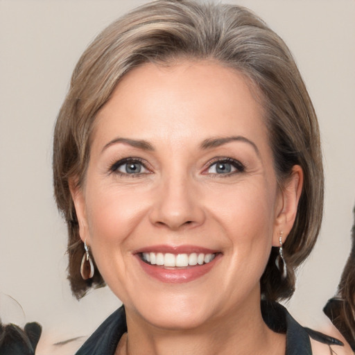 Joyful white adult female with medium  brown hair and grey eyes