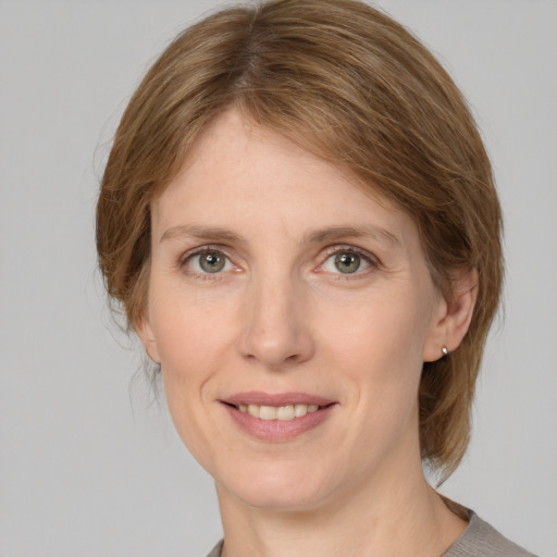 Joyful white young-adult female with medium  brown hair and grey eyes