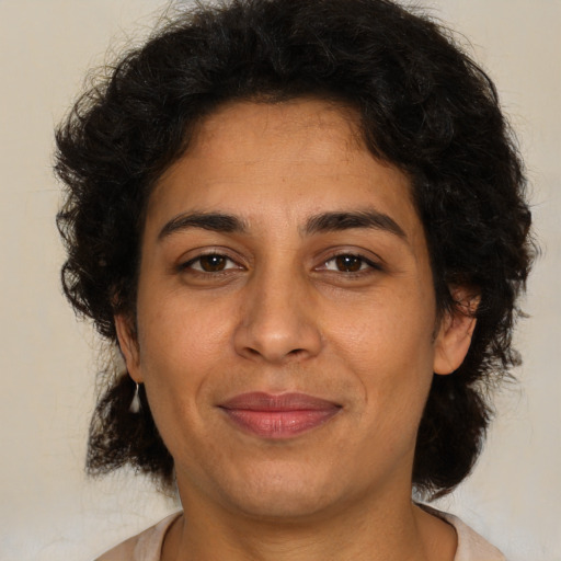 Joyful latino adult female with medium  brown hair and brown eyes