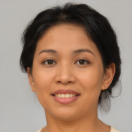 Joyful asian adult female with medium  brown hair and brown eyes